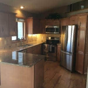 A kitchen with a wood floor and granite counters