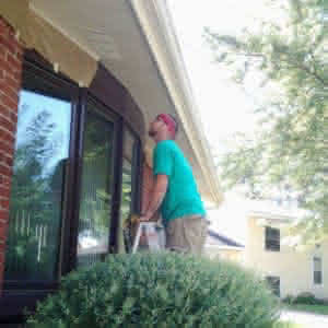 A person on a ladder repairing a roof