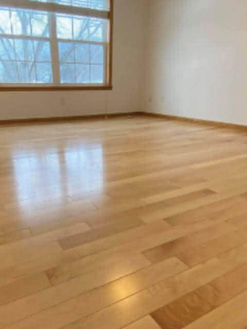 An empty room with hardwood floors